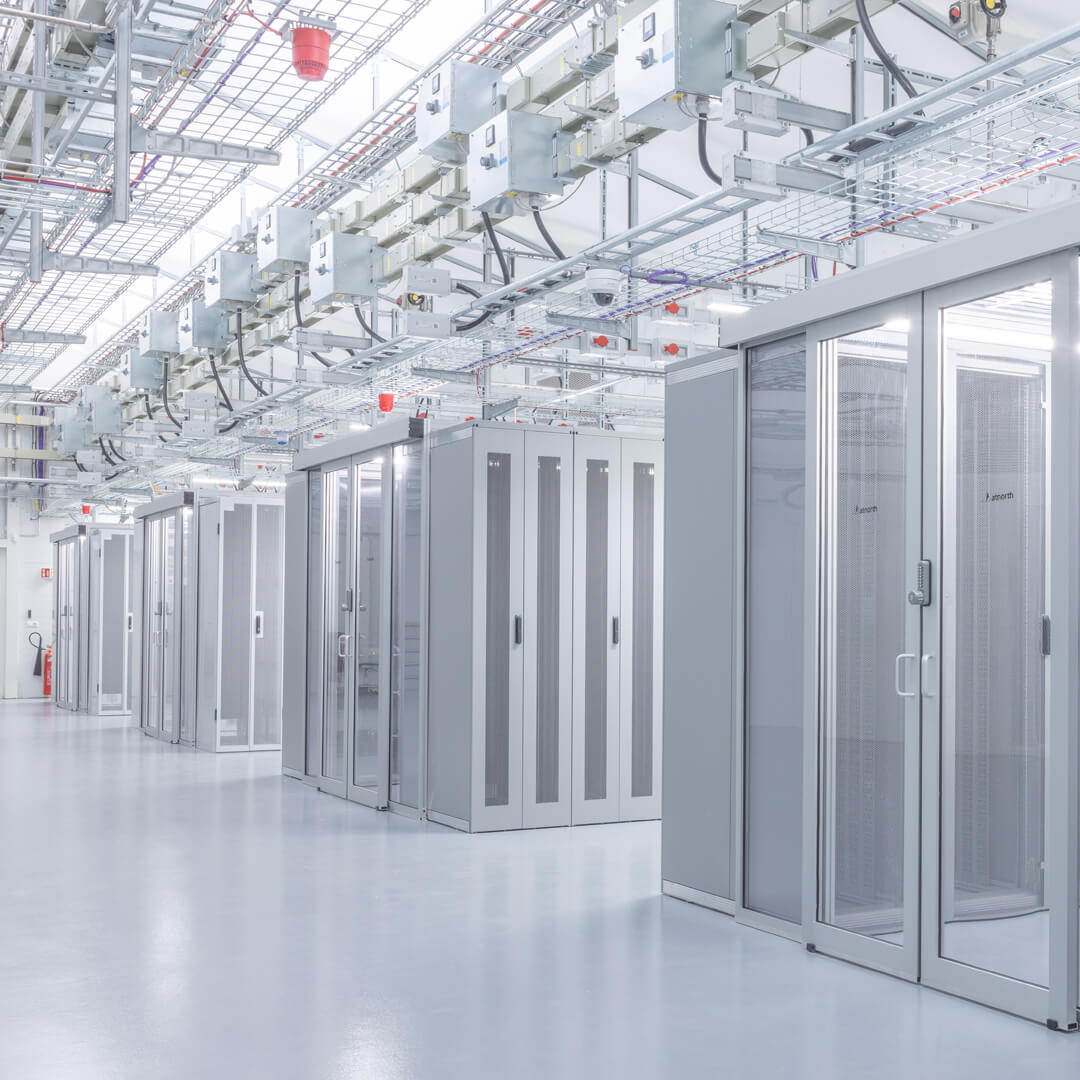 A clean, modern interior of a sustainable data center with rows of server racks and efficient cable management overhead.