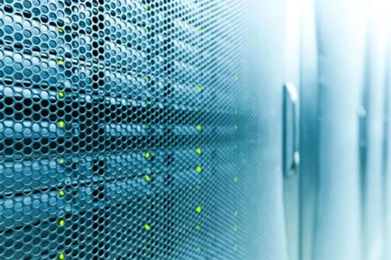 Close-up of a server rack with a perforated metal surface and green indicator lights, nestled in the heart of the data center.