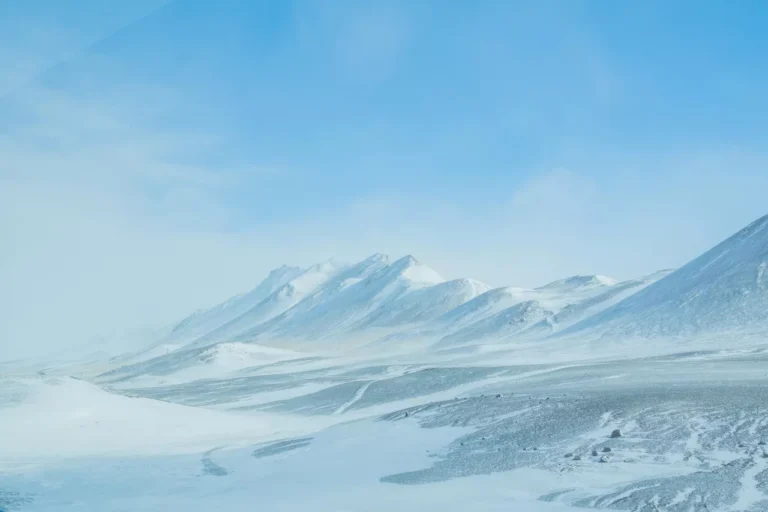 A vast, snow-covered mountain range under a clear blue sky, resembling nature’s serene data center.