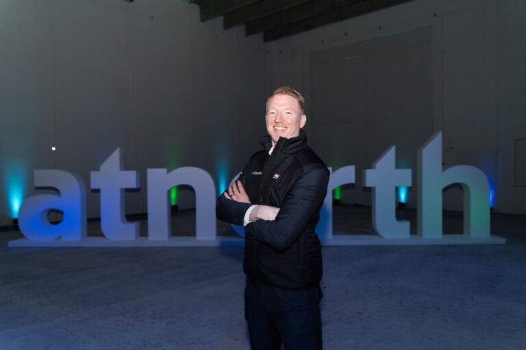 Fredrik Jansson in a black vest stands with arms crossed in front of atNorth logo