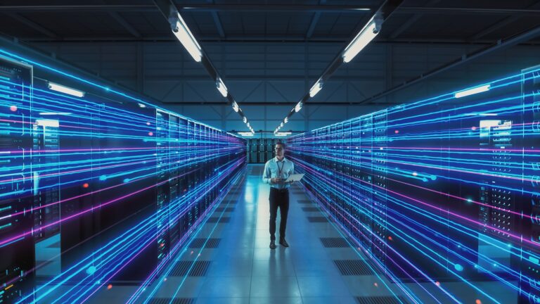 A person walks through a data center corridor with rows of servers. Blue and pink neon lines suggest fast data transfer.