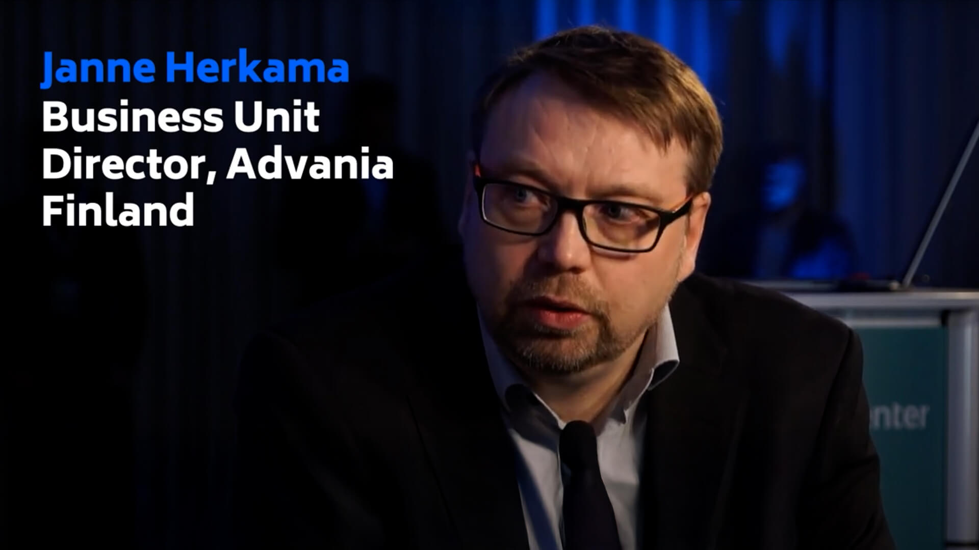 A man with glasses and a beard is speaking. The text beside him reads: "Janne Herkama, Business Unit Director, Advania, Finland.