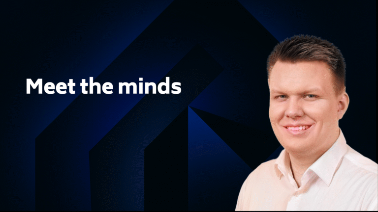 A man in a light-colored shirt smiles at the camera against a dark geometric background with the text "Meet the minds.