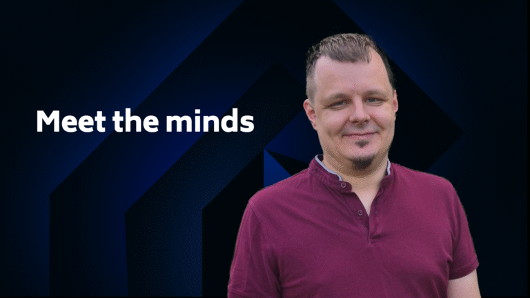 A man in a burgundy shirt stands in front of a dark geometric background with the text "Meet the minds" on the left.