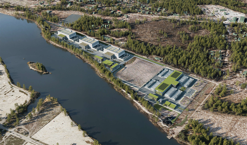 Aerial view of a large industrial complex with multiple buildings along a river, surrounded by forest and cleared land.